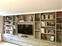 a living room with bookshelves and a flat screen tv