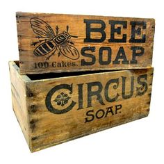 two wooden boxes with bees and soap logos on the front one has a bee in it