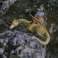 a yellow dragon statue sitting on top of a rock