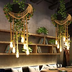 the dining room is decorated with hanging plants and bookshelves, along with decorative lighting fixtures