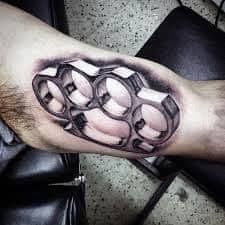 a man with a tattoo on his arm that has handcuffs in the middle of it