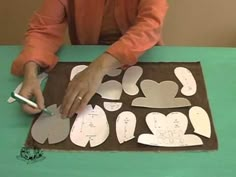 a person cutting out paper shapes on a table