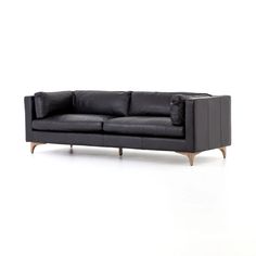 a black leather couch with wooden legs