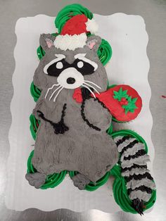 a cake shaped like a raccoon wearing a santa hat