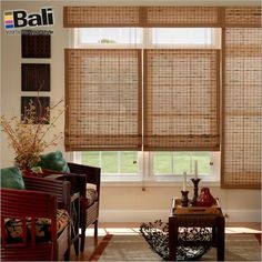 a living room filled with furniture and windows covered in bamboo blind shades on top of them