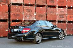 a black car parked in front of stacks of boxes