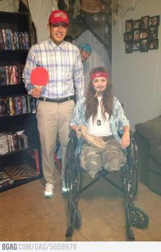 a man standing next to a woman in a wheel chair with a paddle on it