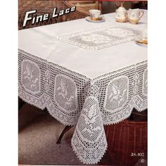 the tablecloth is white and has lacy doily on it, along with two teacups