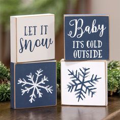 three wooden blocks decorated with snowflakes and words