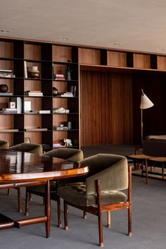 a large wooden table sitting in front of a bookshelf filled with lots of books