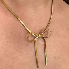 Unleash your wild side with the Lily Bow Necklace. This unique snake chain necklace features a playful, feminine bow design that will add a touch of quirkiness to any outfit. Perfect for the fashion-forward trendsetter, this necklace is sure to make a statement. 18k Gold Plated Over Stainless Steel Hypoallergenic Water & Tarnish Resistant Chic Metal Jewelry With Bow Detail, Chic Snake Chain Necklace With Adjustable Chain, Gold Bow Necklace For Party, Gold Necklace With Bow For Party, Dainty Snake Chain Necklace For Party, Chic Ribbon Jewelry As A Gift, Chic Jewelry With Ribbon For Gift, Chic Ribbon Jewelry For Gifts, Chic Ribbon Necklace Perfect For Gifts