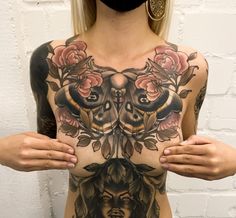 a woman with tattoos on her chest and face is wearing a mask to protect herself from the sun