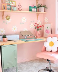 a pink desk and chair in a room with flower wallpaper on the walls behind it