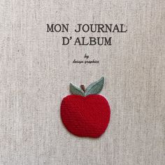 an apple brooch with the words mon journal d'album written on it in french