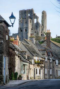 an old stone building sitting on the side of a road