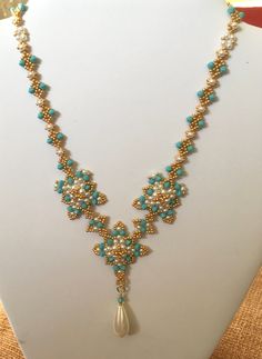 This beautiful Edwardian style Necklace is made with Toho  glass seed beads with faux pearls and Precoisa turquoise colours crystal bicones. The clasp is a simple hook and eye made from vermeil (18ct gold plated 925 Silver).  Elegant easy to wear. Ideal for special occasions and a themed party. Elegant Turquoise Beaded Necklaces With Gold Beads, Elegant Turquoise Beaded Necklace With Gold Beads, Adjustable Gold Beaded Necklaces With Bead Caps, Elegant Turquoise Beaded Necklaces With Spacer Beads, Elegant Turquoise Beaded Necklace With Spacer Beads, Elegant Turquoise Beaded Chain, Turquoise Beaded Necklace With Gold Round Beads, Elegant Turquoise Jewelry With Gold Beads, Handmade Turquoise Pearl Beaded Necklace