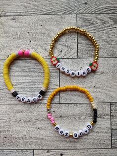 three beaded bracelets sitting on top of a wooden floor next to each other