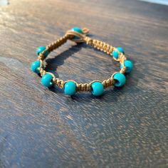 a blue beaded bracelet on a wooden table