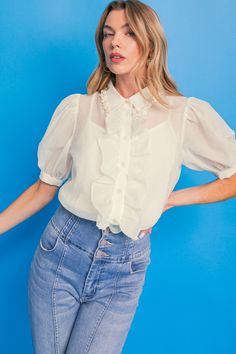 This EASY ESSENTIAL IVORY WOVEN TOP is a timeless and stylish choice. It features a solid woven fabric, pearl embellishment trim along the shirt collar, button down with ruffles, and short sleeves. This top is perfect for any occasion, from casual to semi-formal events. DetailsSelf : 100% PolyesterLining : 100% Polyester Size & Fit- Model is 5`8" And Wearing Size Small- Measurements Taken From Size Small- Approx. Length: 25" Daywear Collared Blouse With Ruffles, Feminine Blouse With Button Closure And Ruffled Collar, Feminine Blouse With Ruffled Collar, Feminine Blouse With Ruffled Collar And Button Closure, Spring Chic Blouse With Pearl Buttons, Classic Tops With Pearl Buttons For Spring, Chic Blouse With Ruffled Collar And Buttons, Chic Blouse With Ruffles And Peter Pan Collar, Chic Blouse With Peter Pan Collar And Ruffles