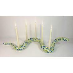 a snake like candle holder with five candles