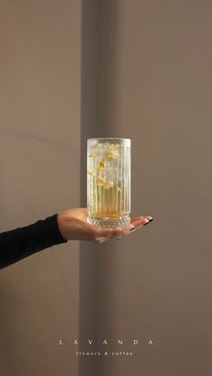 a person holding a glass with some liquid in it