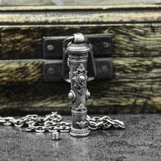 a metal object sitting on top of a table next to a chain attached to it