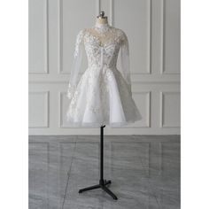 a wedding dress on a mannequin stand in front of a white wall and floor