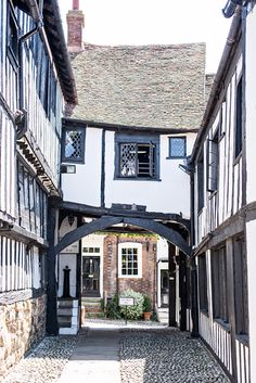 an alley way with old buildings and cobblestone pavement in the foreground, surrounded by stone walls