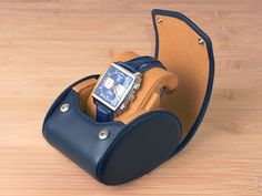 "This is the original watch roll with slide-in system, invented and designed by Carapaz in Switzerland. Unlike some cheaper imitations using our system, we do not produce in Asia and use only quality materials, such as full grain leather. We also do not copy anyone else's designs. TRAVEL WATCH CASE FOR 1 WATCH - WITH STAND FUNCTION - COMES IN GIFT BOX Color: NAVY BLUE with tan interior This is our brand-new watch case design, featuring a stand function. It lets the watch being displayed upright Blue Rectangular Business Watches, Blue Watch Accessories For Gift, Classic Blue Rectangular Watch Accessories, Rectangular Chronograph Watch Accessories For Business, Rectangular Blue Watch Accessories For Gift, Leather Watch Box, Watch Roll, Travel Storage, Watch Box