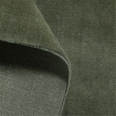 a close up view of the fabric on an olive green colored suit with black piping