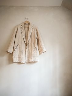 a white jacket hanging up against a wall