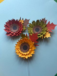 three paper sunflowers on a blue background