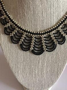 a black and white beaded necklace on a mannequin's neckline