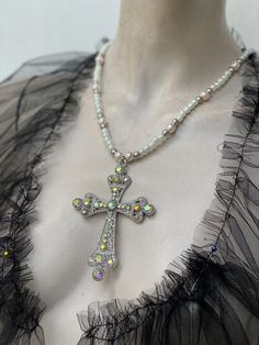 Large filigree cross pendant pearl chain. Cross has iridescent rhinestone. I have used two colour pears for the chain. Light cream rose 10 mm glass pearls and ivory 6 mm glass pearls. Cross is zinc alloy. I can do any colour pearls to suit you. Spiritual Cross-shaped Pearl Chain Jewelry, Cross Pendant Necklace With Pearl Charm, Silver Cross Necklace With Pearl Chain For Gift, Silver Cross Necklace With Pearl Chain As Gift, Silver Beaded Cross Pendant Jewelry, Silver Cross Necklace With Pearl Chain, Silver Cross Pendant Necklace With Pearl Chain, White Cross Necklace With Pearl Pendant, Silver Cross Jewelry With Pearl Chain