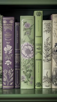 a row of books sitting on top of a green book shelf next to each other