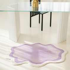 a glass table with a purple rug on it