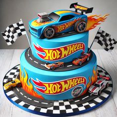 a three tiered cake with hot wheels on top