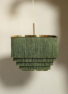 a green chandelier hanging from a ceiling with fringes on the bottom and sides