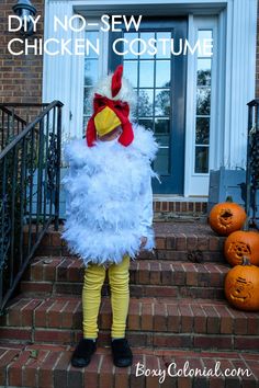 a little boy dressed as a chicken standing on the steps in front of a house