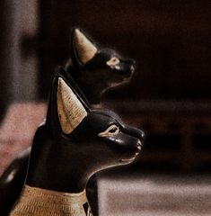 an egyptian statue is shown in black and gold colors with horns on it's head