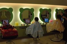 a woman getting her hair cut in front of a mirror with teddy bears on it