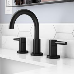 two black faucets on a white counter top