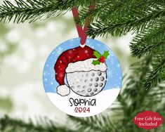 a christmas ornament with a golf ball and santa hat hanging from a tree