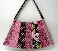 a pink and black purse hanging on a wall