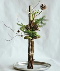 there is a vase with pine cones and flowers in it