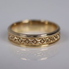 two gold wedding bands with intricate designs on them