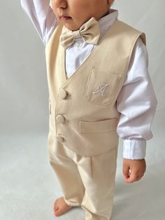 ✿ABOUT THIS SUİT ✓Our handmade 5-piece set featuring a baby boy ecru suspender pants, hat, bow tie, vest, and white shirt. ✓Our suit is made from a luxurious blend of cotton and silk alpaca fabric. ✓The suit is available in a range of color options to suit any style or preference.  ✓The vest can even be personalized with letter embroidery upon request, making it a truly one-of-a-kind piece. ✓The trousers feature elastic at the back, ensuring a comfortable fit, while the straps can be adjusted in Fitted Beige Cotton Sets, Fitted Beige Sets For Baptism, Cream Cotton Sets For Baptism, Fitted Cotton Off White Sets, Fitted Cotton Sets In Off White, Fitted Embroidered Beige Sets, Classic Cotton Beige Set, White Embroidered Cotton Vest, Classic Beige Cotton Set