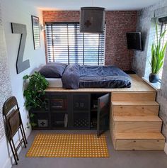 a bed sitting on top of a wooden platform next to a window