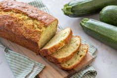 sliced zucchini bread on a cutting board next to cucumbers