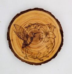 a piece of wood with an image of a bird and flowers on it's side